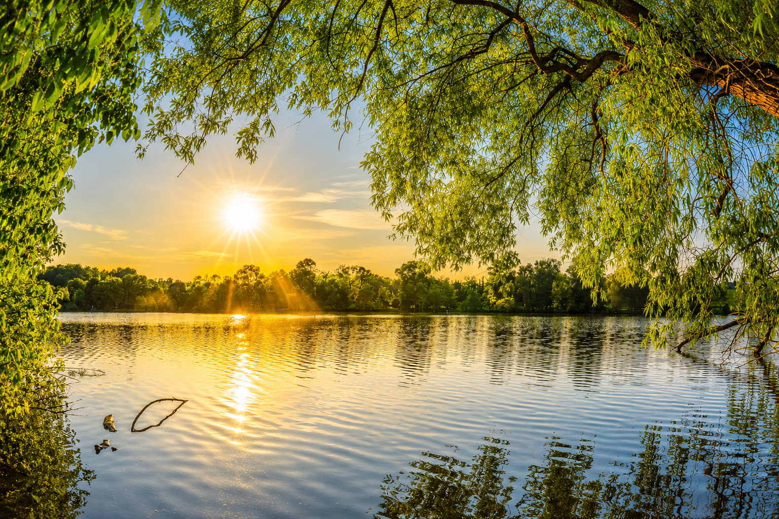 Reinigungsmittel Camping biologisch am malerischen See bei Sonnenuntergang mit grünem Ufer.